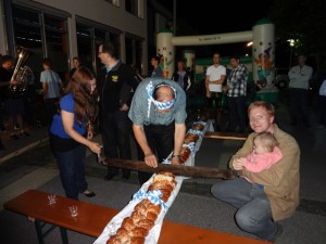 Der Weisatwecken  wird von den Eltern mit der Säge zerschnitten