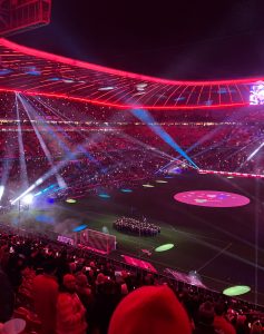 Blick aus dem Stadion auf das Spielfeld, auf dem die Blaskapelle steht.